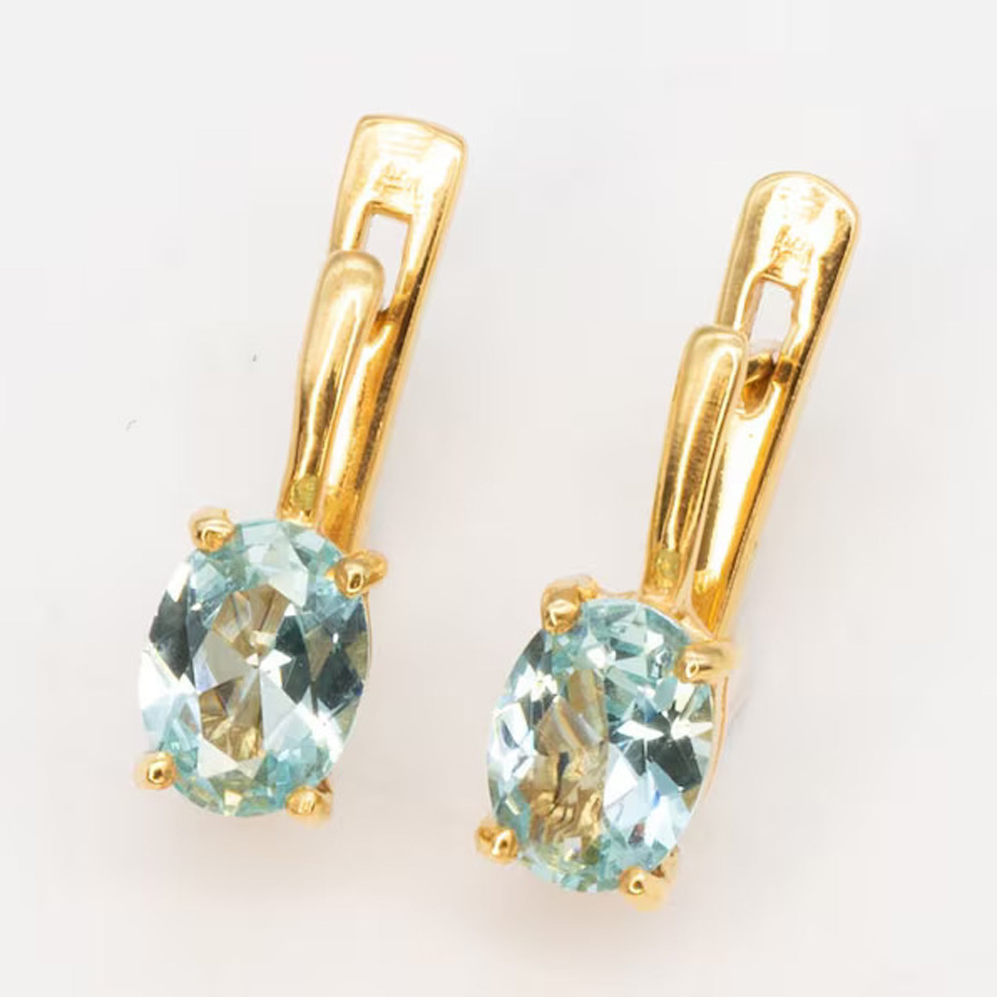 Gold aquamarine earrings with a brilliant blue stone